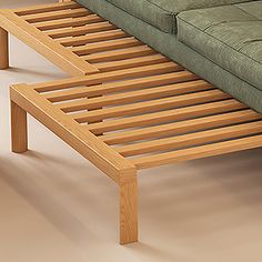 a green couch sitting next to a wooden coffee table