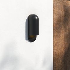 a black door handle is on the side of a white wall with a wooden door