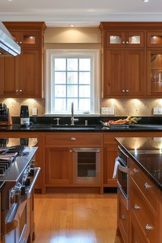 a kitchen with wooden cabinets and black counter tops, along with stainless steel oven hoods