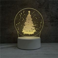 a snow globe with a lit up christmas tree in it on top of a table