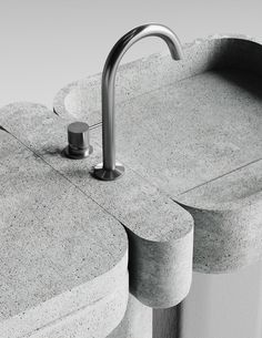 a sink made out of concrete with a metal faucet