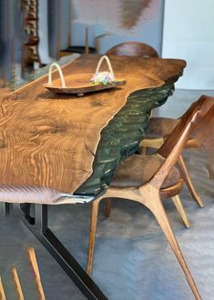 a wooden table with two chairs and a plate on it's end, in a room