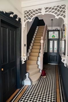 a black and white checkered floor with stairs leading up to the second story door