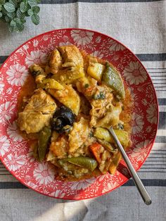 a red plate topped with chicken and vegetables