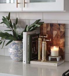 a candle and some books on a kitchen counter