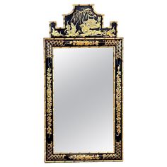 a black and gold mirror with an ornate design on the front, against a white background