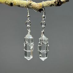 Clear Quartz Crystal Dangle Earrings, Quartz Gemstone Wire Wrapped Earrings  You will receive 1 (ONE) Pair of Clear Quartz Dangle Earrings like the item pictured.   Item description Stone: Clear Quartz  Finish: Polished, wire wrapped Drop length: 50mm Length: 30mm Width: 10mm These raw crystal earrings celebrate the natural beauty of clear quartz jewelry. The translucent beauty of quartz crystal captures the light and adds a touch of elegance to any outfit. Handmade with care, these gemstone ear Clear Quartz Earrings, Astrology Outfits, Clear Quartz Jewelry, Raw Crystal Earrings, Crystal Quartz Earrings, Quartz Crystal Jewelry, Silver Crystal Earrings, Emerald Green Earrings, Dark Crystal