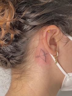 a woman with a small tattoo behind her ear