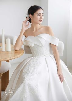 a woman in a white dress sitting at a table