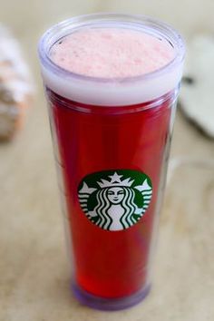 a red starbucks cup sitting on top of a table