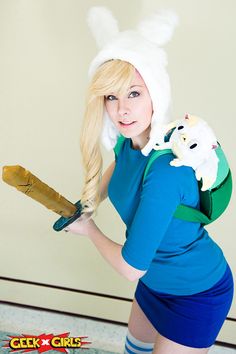 a woman in bunny ears is holding a pair of scissors and wearing a blue dress