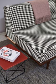 a living room with a checkered couch and small table on the floor next to it