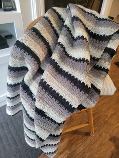 a crocheted blanket sitting on top of a wooden chair