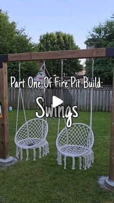 two white chairs sitting on top of a wooden swing set in the middle of a yard