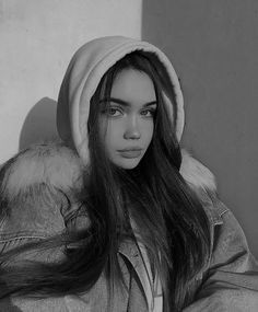 black and white photograph of a woman with long hair wearing a hoodie over her head