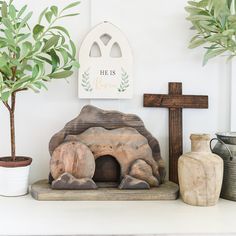 a cross, potted plant and statue on a shelf