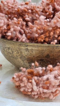 a metal bowl filled with pink and brown yarn