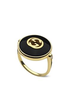 a black and gold ring with the letter g on it's center, set in 18k yellow gold