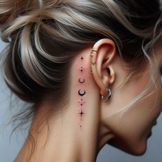 a woman's ear with the moon and stars tattoo on her left behind the ear