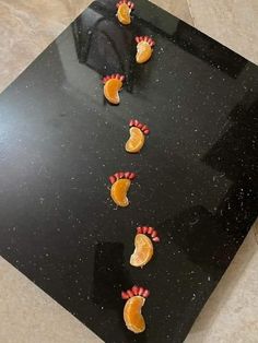 orange slices are arranged in the shape of hearts on a black table with marble flooring