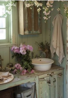 a bathroom sink sitting under a mirror next to a wooden cabinet with flowers on it