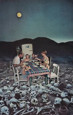 a group of people sitting around a table with skulls on the ground in front of them