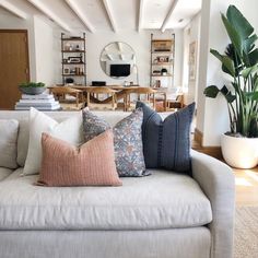 a living room filled with lots of furniture and pillows on top of a white couch