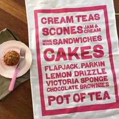 a pink and white tea towel sitting on top of a table next to a cupcake