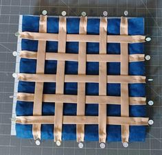 a piece of blue and tan fabric with some holes cut out to look like woven squares