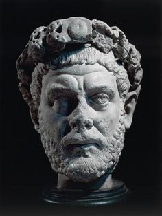 an ancient bust of a man wearing a crown