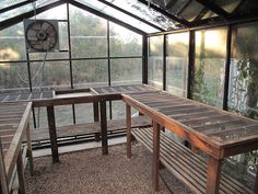 the inside of a greenhouse with benches and tables