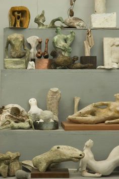 there are many different sculptures on the shelves