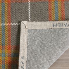 the back end of an upholstered plaid fabric with a name tag on it