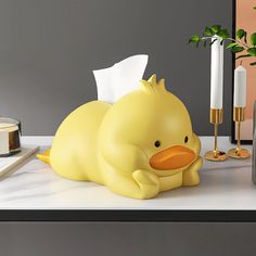 a yellow rubber duck laying on top of a counter next to a candle and some candles