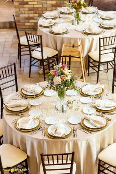 the table is set with white and gold plates