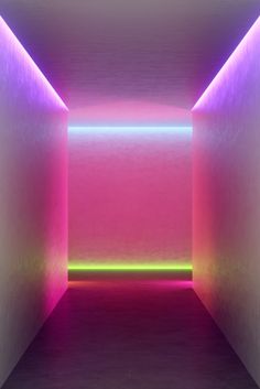 an empty room with neon lights in the corner and floor to ceiling lighting on either side