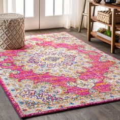 a pink and yellow area rug in a living room