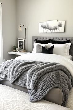 a bedroom with a large bed and white comforter on top of the bed, along with black and white decor