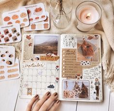 a person's hand on top of a table with many different items and candles