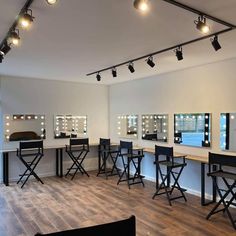 an empty room with several stools and mirrors