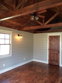 an empty room with wood floors and ceiling fan