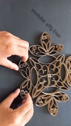 two hands are working on an intricately designed object