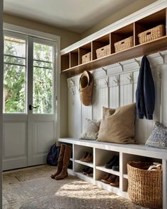 a white bench sitting next to a window filled with lots of pillows and baskets on top of it