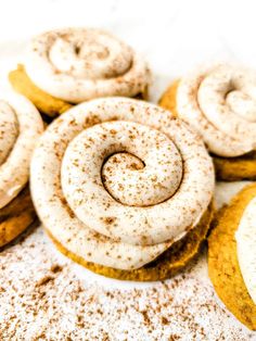 cinnamon rolls with powdered sugar on top and cookies in the background, ready to be eaten