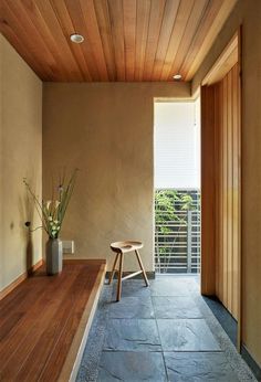 a wooden bench sitting in the middle of a room next to a door and window