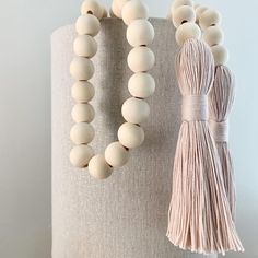 a white beaded necklace and tassel on a table