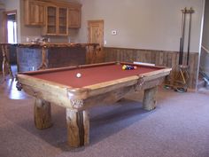 a pool table is in the middle of a room with other items on the floor