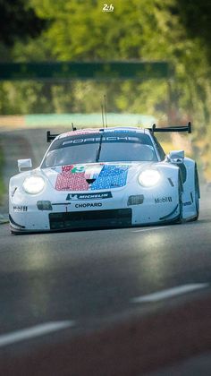 a white race car driving down the road