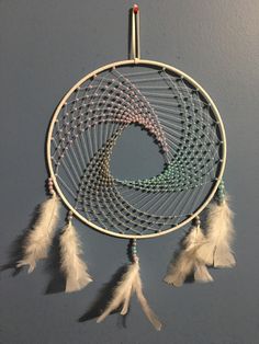 a white dream catcher hanging on the wall