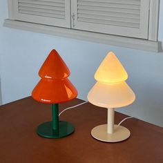 two lamps sitting on top of a wooden table